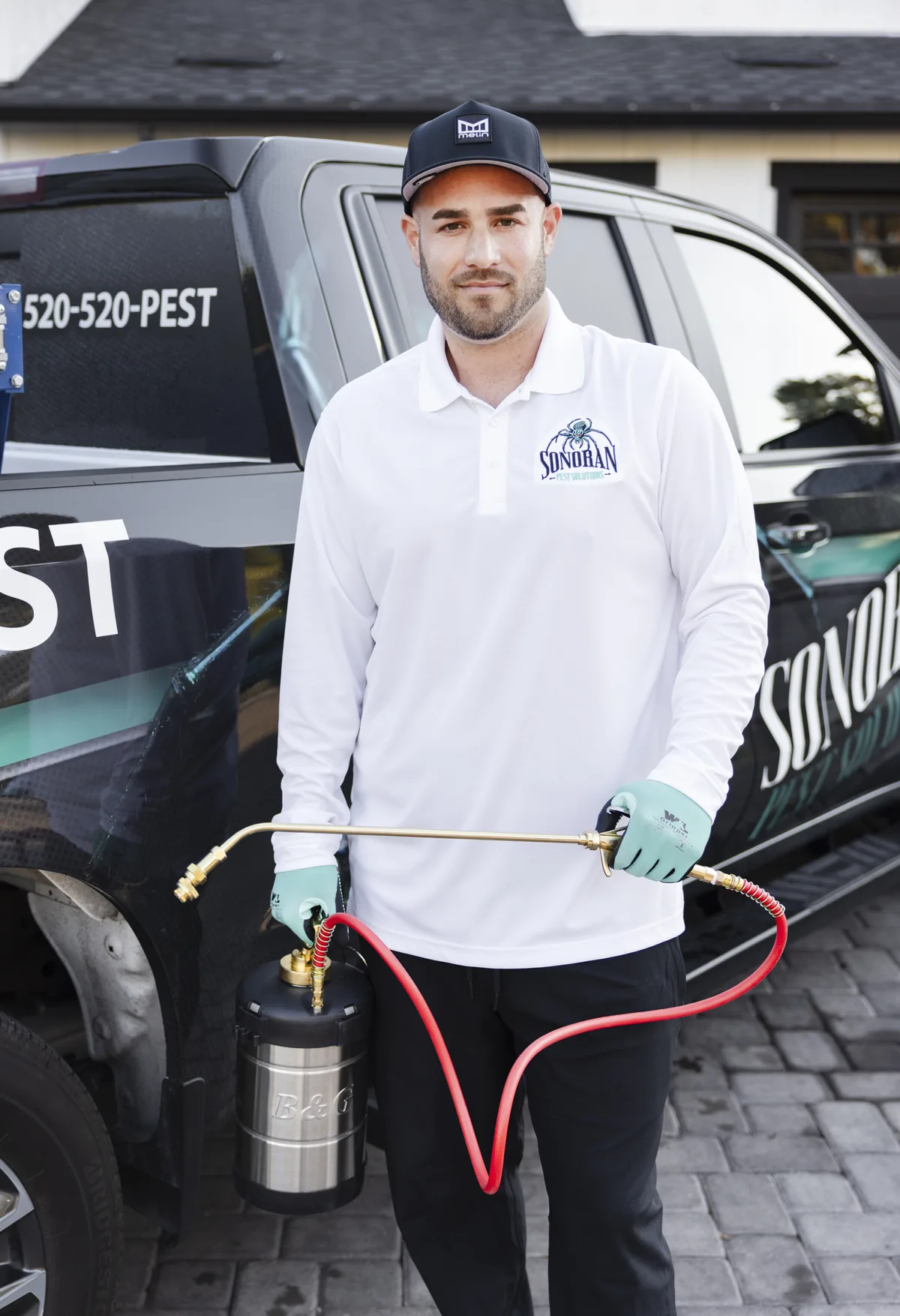 Michael of Sonoran Pest Solutions with his sprayer in front of the company truck