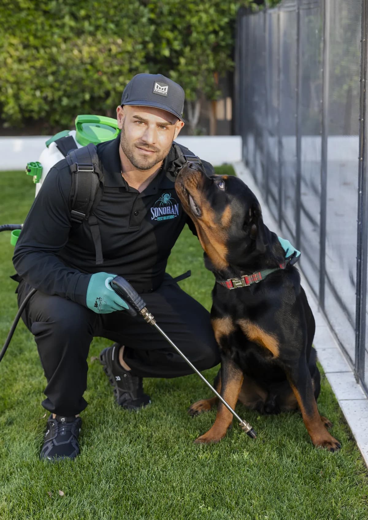 Technician kneeling beside a family dog — treatments safe for pets